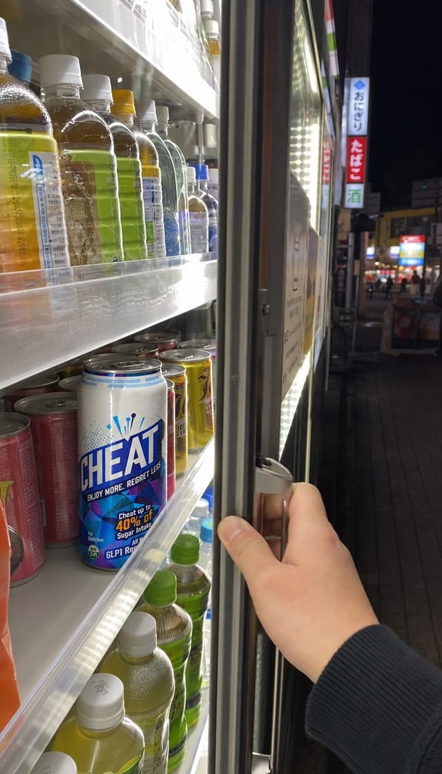 Inside a Japanese convenience store at night, the glowing beverage fridge aisle with glass doors, cold fluorescent light, dense shelves, ver